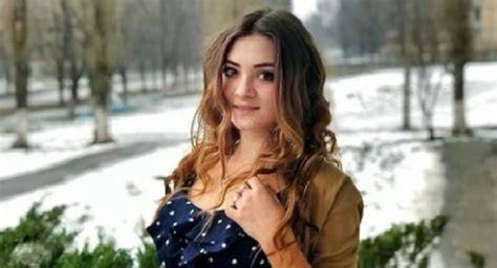 Aleksandra Zelenskaya in a light green dress hugging her mother in a white t-shirt and blue jeans.